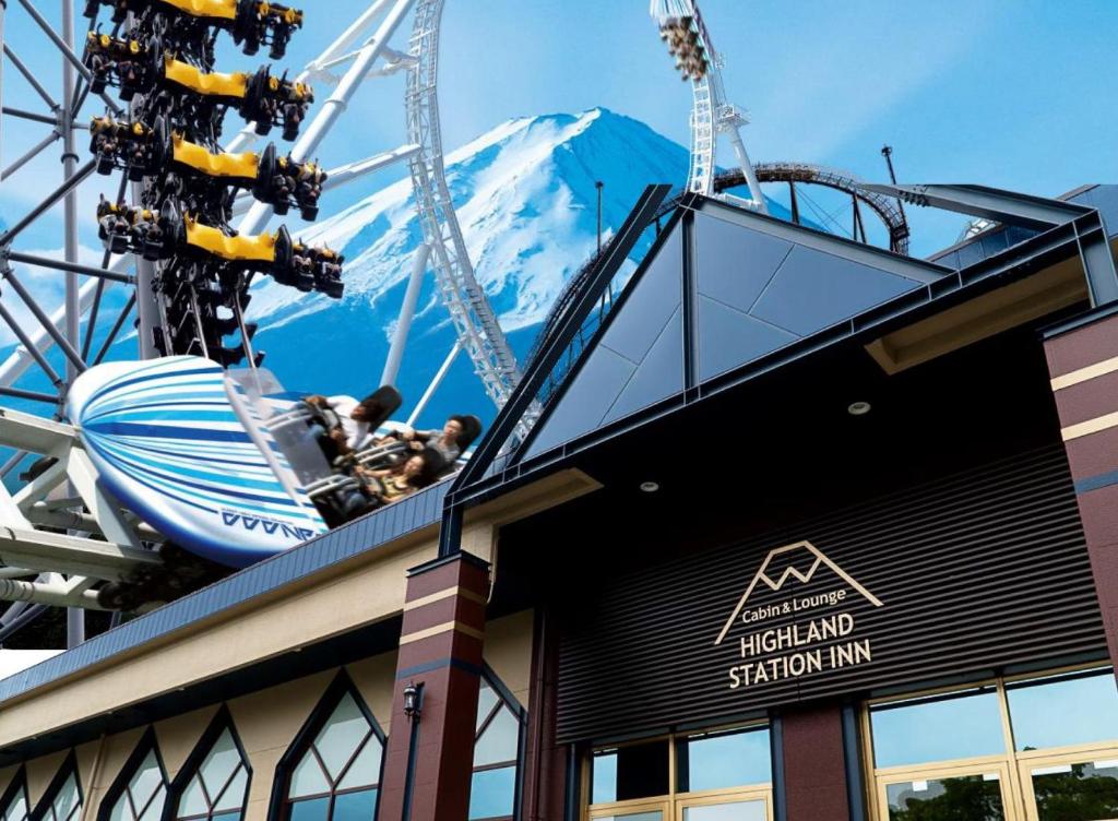 une roue ferris avec une montagne en arrière-plan dans l'établissement Mt.Fuji Cabin & Lounge Highland Station Inn (Capsule Hotel), à Fujikawaguchiko