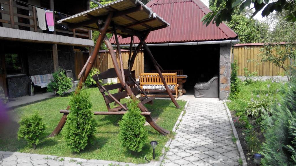 a gazebo with a bench in a yard at uoksany in Karpaty