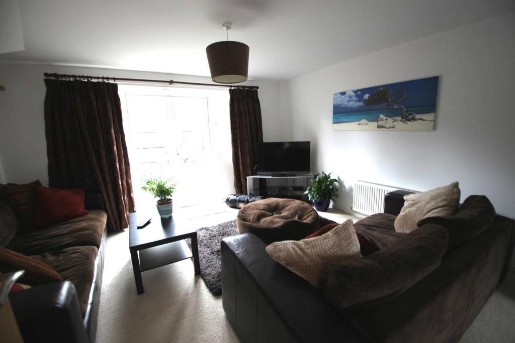 a living room with a couch and a tv at Lymm House in Lymm
