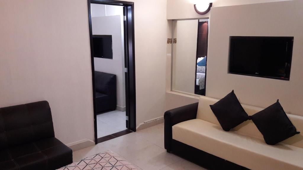 a living room with a couch and a mirror at Hotel La Torre San Francisco in San Francisco del Rincón