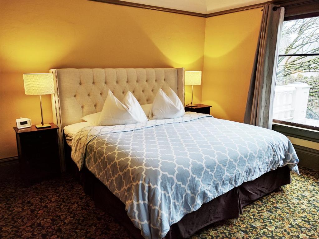 a bedroom with a bed with a white bedspread and a window at Evermore Guesthouse in Portland