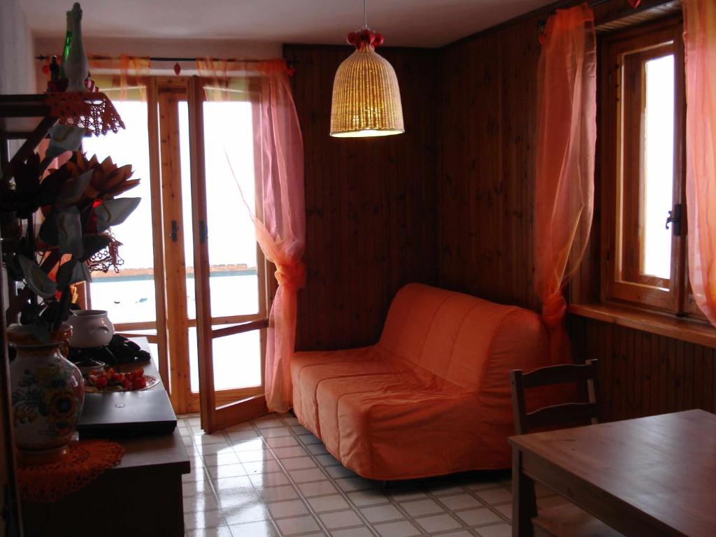 Mirtilli في براتو نيفوسو: غرفة معيشة مع أريكة برتقالية وطاولة
