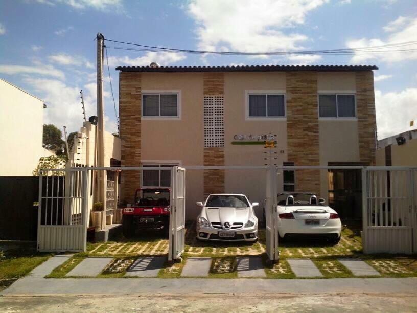 une voiture blanche garée devant une maison dans l'établissement Flats Gol de Placa, à Fortaleza