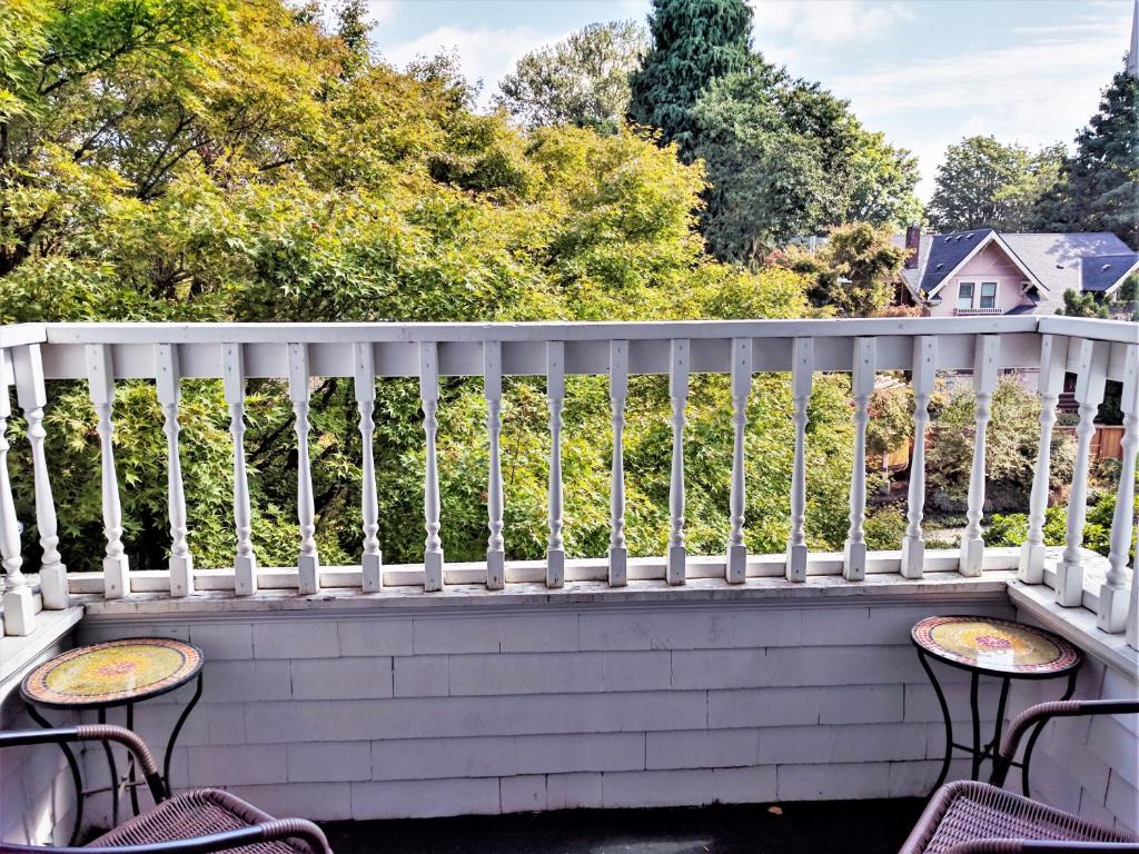 a white railing on a porch with chairs at Evermore Guesthouse in Portland