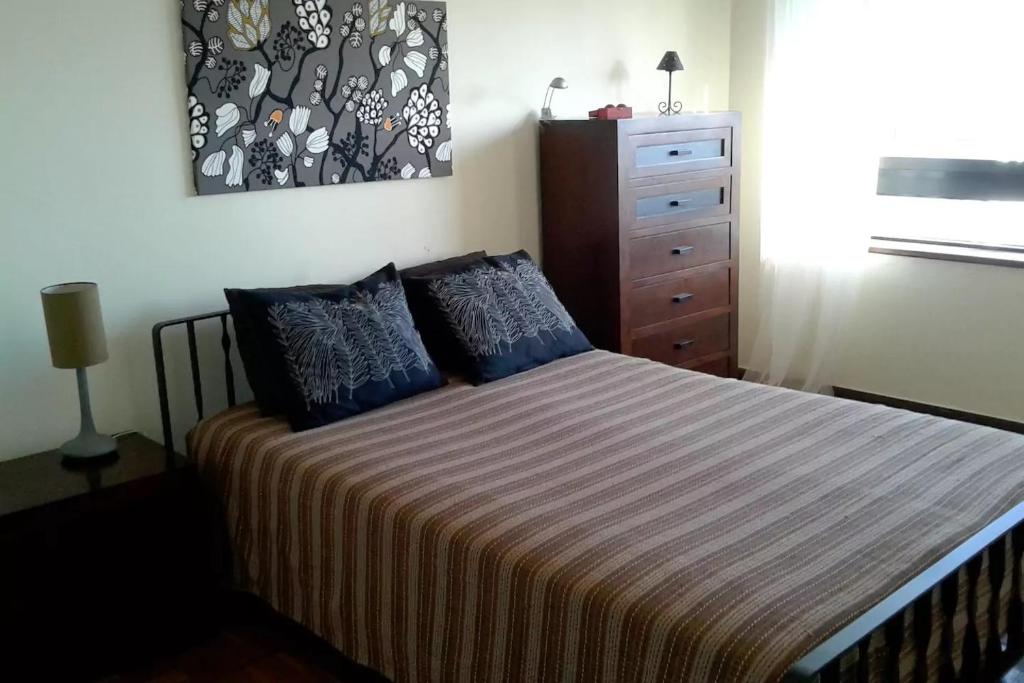 セトゥーバルにあるApartamento Luisa Todiのベッドルーム1室(青い枕とドレッサー付きのベッド1台付)