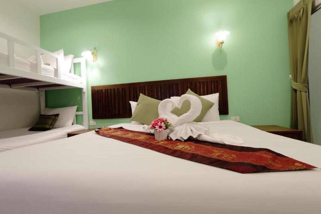 a large white bed with a swan decoration on it at BS Airport at Phuket in Nai Yang Beach