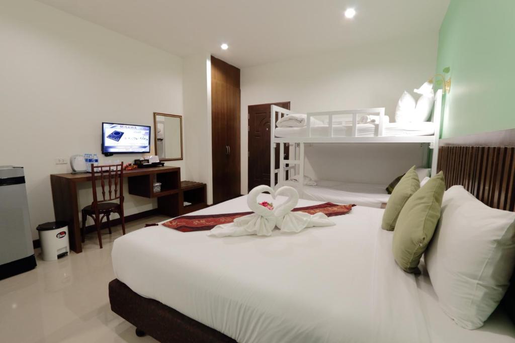 a bedroom with a white bed with a white flower on it at BS Airport at Phuket in Nai Yang Beach