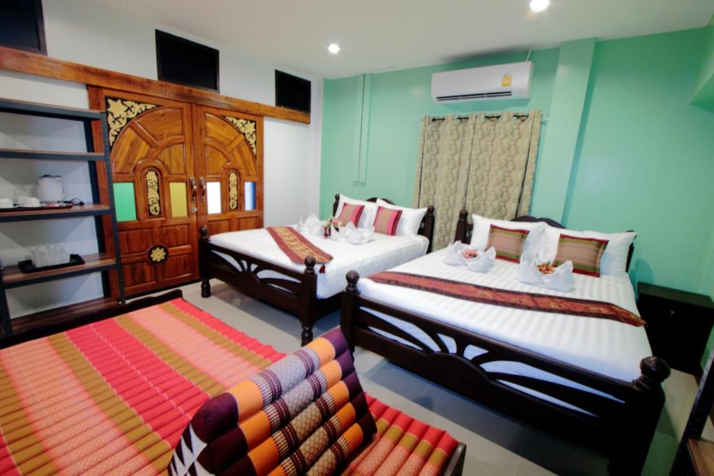 a bedroom with two beds and a couch in it at BS Airport at Phuket in Nai Yang Beach
