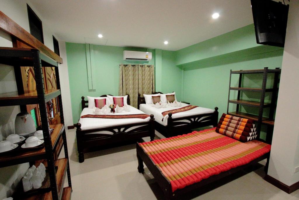 a room with two beds and a couch in it at BS Airport at Phuket in Nai Yang Beach