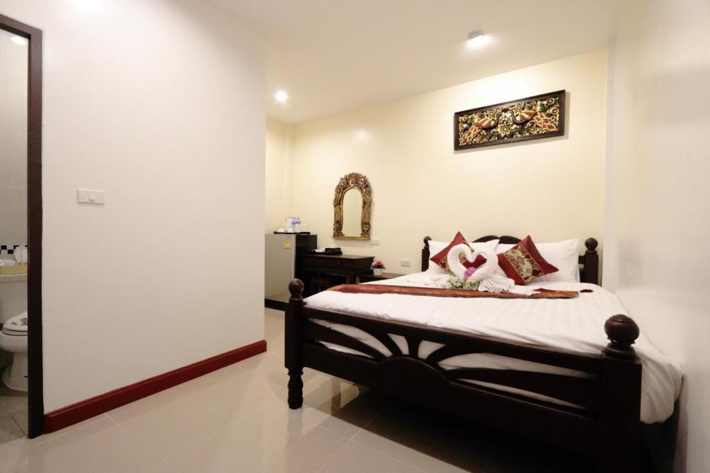 a bedroom with a bed and a sink and a mirror at BS Airport at Phuket in Nai Yang Beach