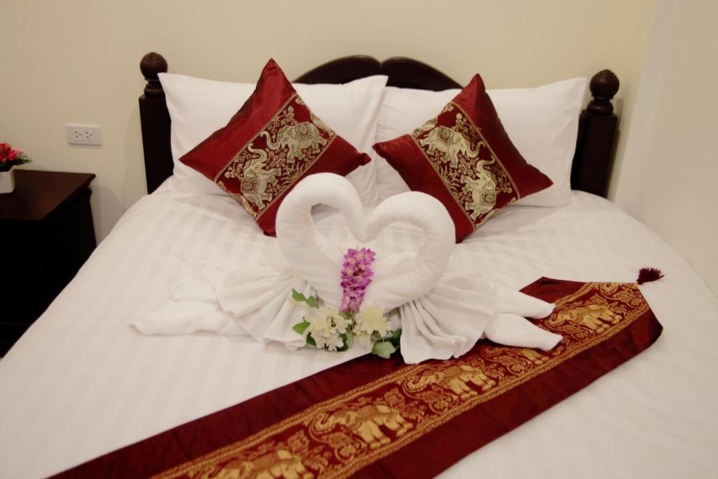 a bed with a white flower on top of it at BS Airport at Phuket in Nai Yang Beach