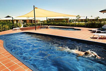 a swimming pool in a yard with a tent at Potters Apartments in Cessnock