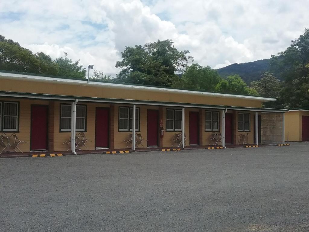 un edificio con muchas ventanas en un estacionamiento en Murrurundi Motel, en Murrurundi