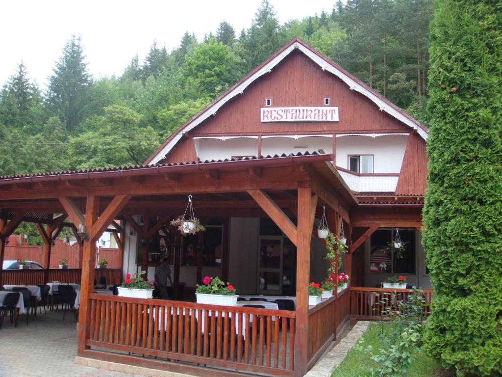 ein großes Holzgebäude mit einem Restaurant darauf in der Unterkunft Motel Cristina in Bicaz