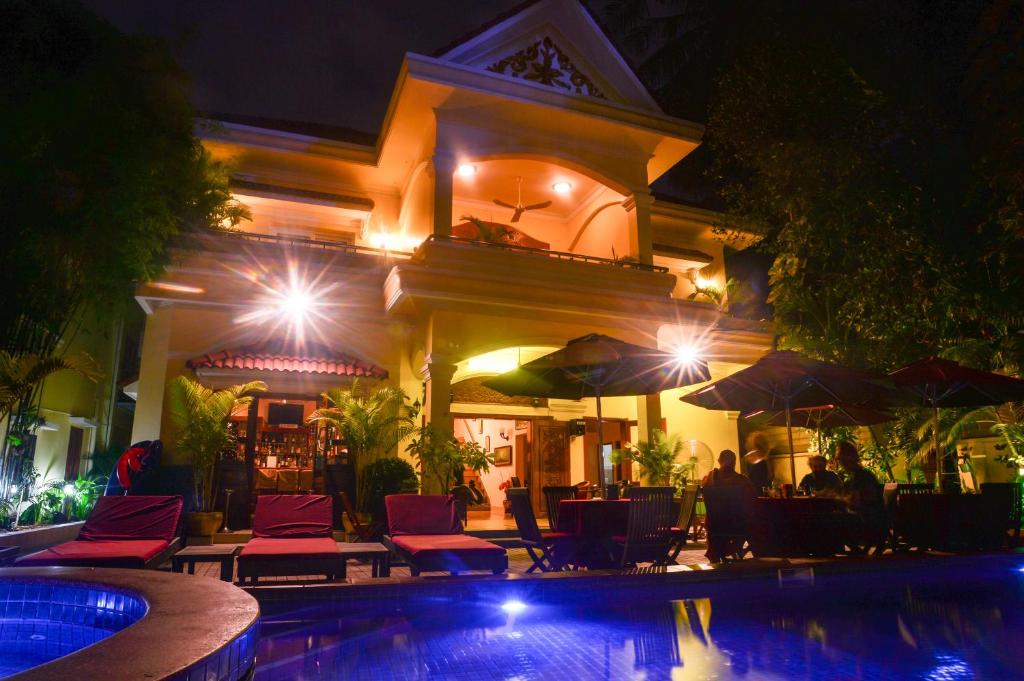 un complexe avec une piscine ouverte la nuit dans l'établissement Villa Grange, à Phnom Penh