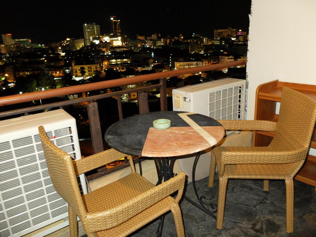 a table and chairs on a balcony with a view at Kao karat in Pattaya