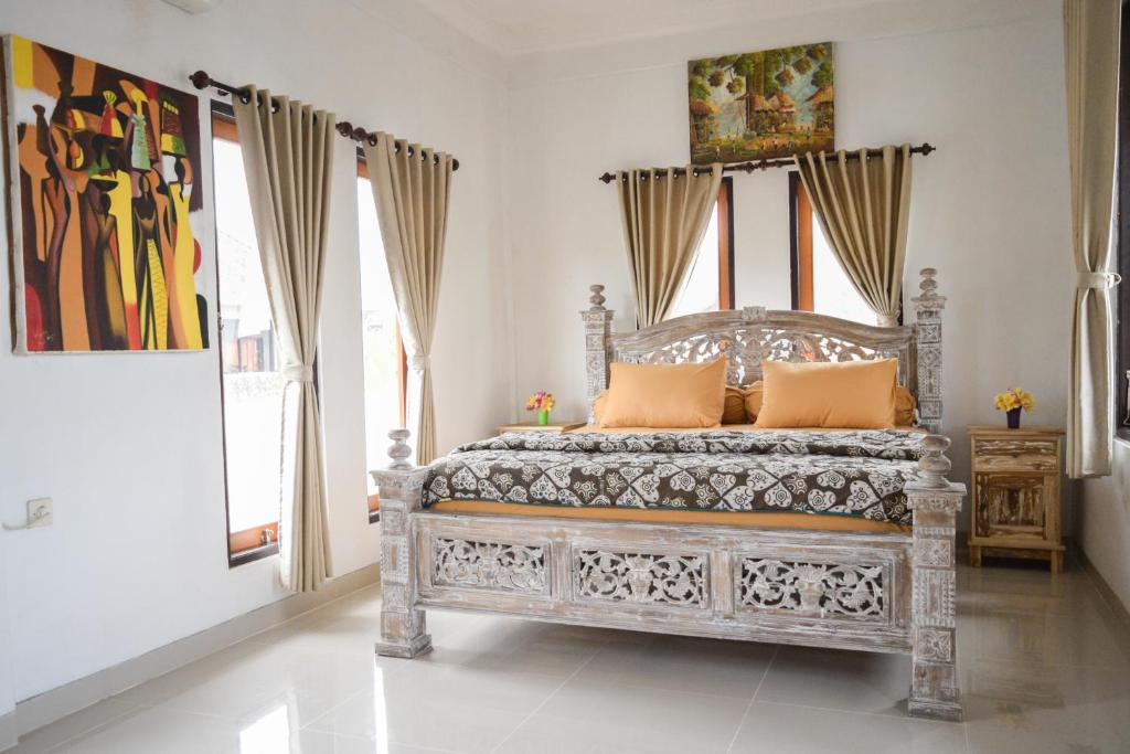 a bedroom with a large bed with orange pillows at Bay View House in Padangbai