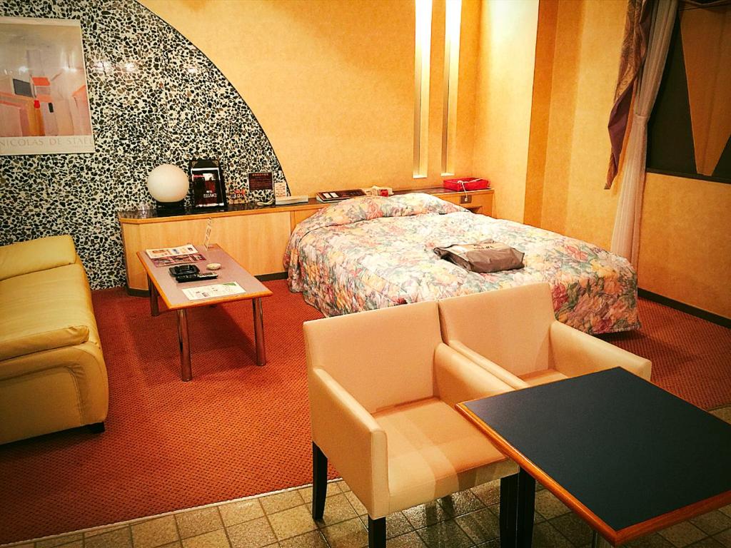 a hotel room with a bed and a table and chairs at Hotel Elegance (Love Hotel) in Karatsu