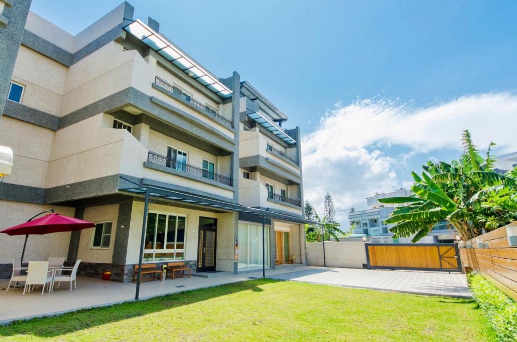 an apartment building with a lawn in front of it at Soar B&B in Taitung City