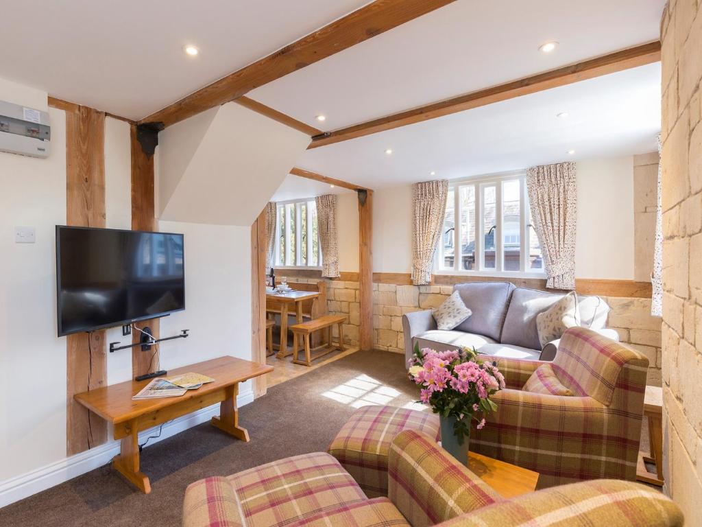 a living room with couches and a flat screen tv at St Kenelm in Winchcombe