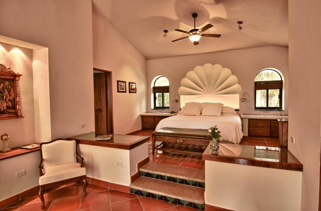 Hacienda Todos Los Santos في تودوس سانتوس: غرفة نوم بسرير وطاولة وكراسي