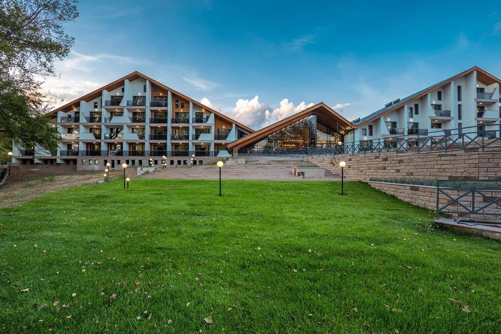 ein Gebäude mit einem Grasfeld davor in der Unterkunft Park Hotel Asarel in Panagjurischte