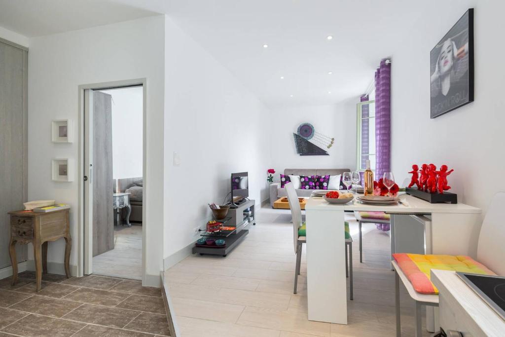 - une cuisine et une salle à manger avec des murs blancs et une table dans l'établissement LE ROSSETTI 2 - F2 LUMINEUX, ASCENSEUR, CLIMATISATION, COEUR Vieux-Nice, à Nice