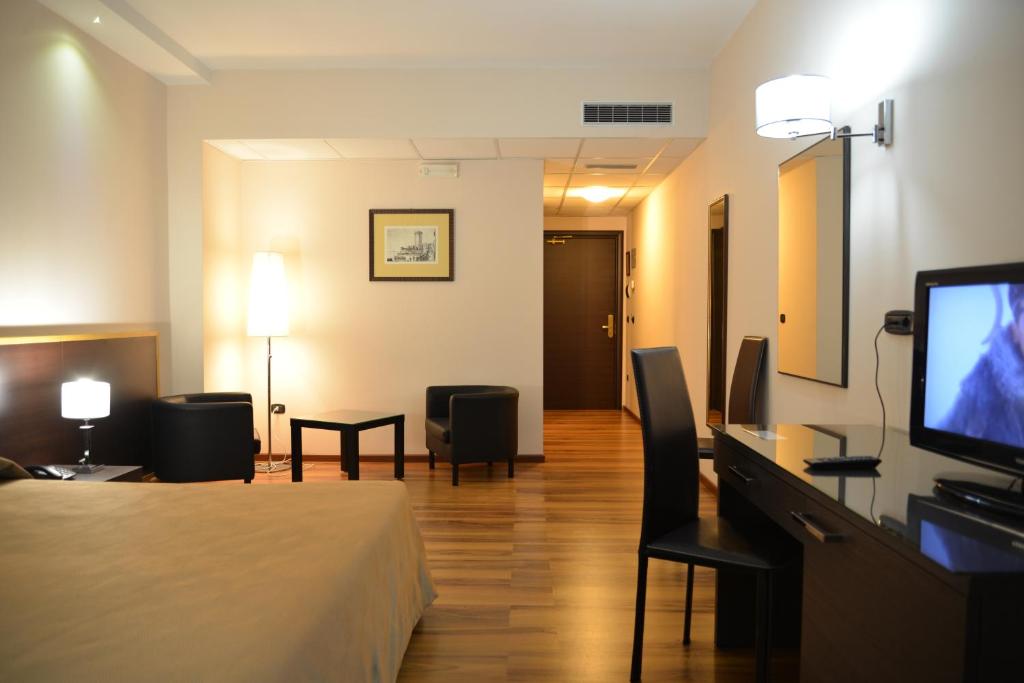 um quarto de hotel com uma cama e uma televisão de ecrã plano em Forum Palace Hotel em Cassino