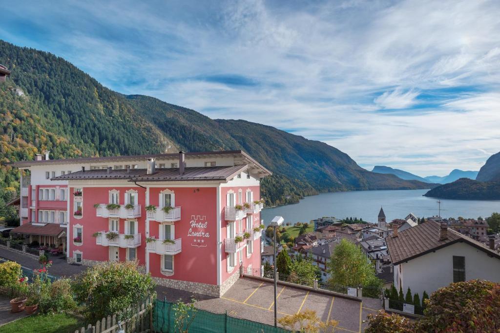 a view of a town with a lake and mountains at Hotel Londra Slow Living Molveno in Molveno