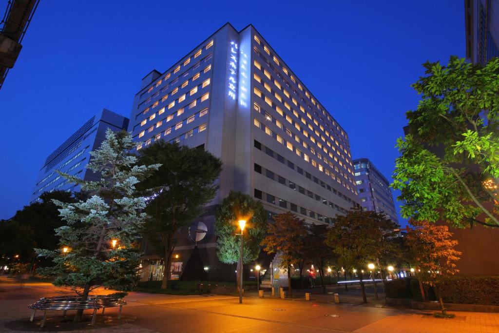 un edificio alto con luces encendidas por la noche en Palace Hotel Tachikawa, en Tachikawa