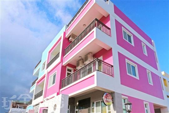 un edificio rosa con balcón en la parte superior en Hai Bed and Breakfasts en Taitung