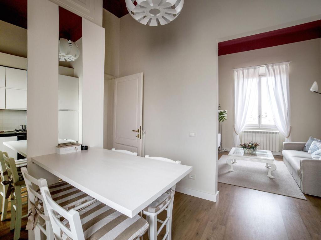 Il dispose d'une cuisine et d'un salon avec une table et des chaises blanches. dans l'établissement Casa Desy, à Forte dei Marmi