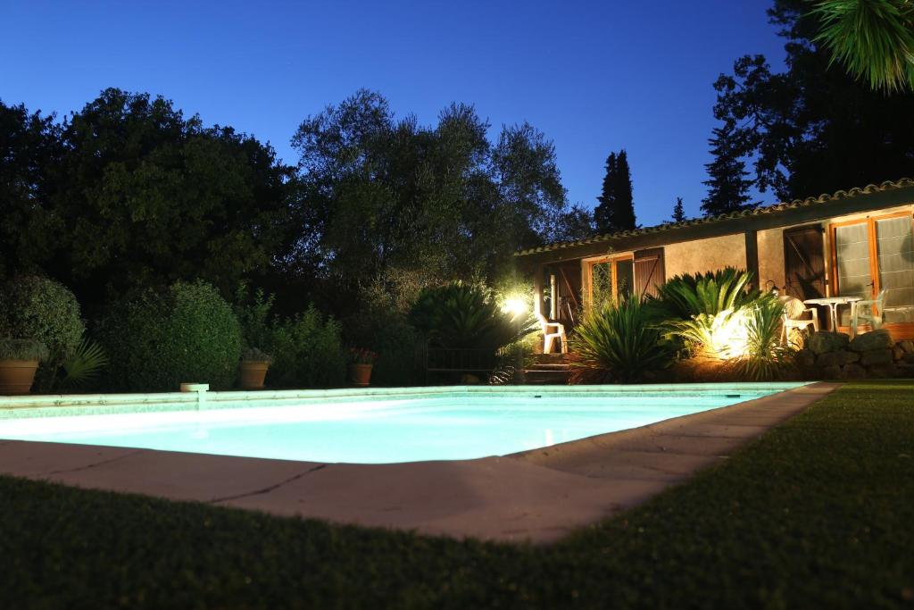 uma piscina em frente a uma casa à noite em La Bastidasse em La Roquette-sur-Siagne