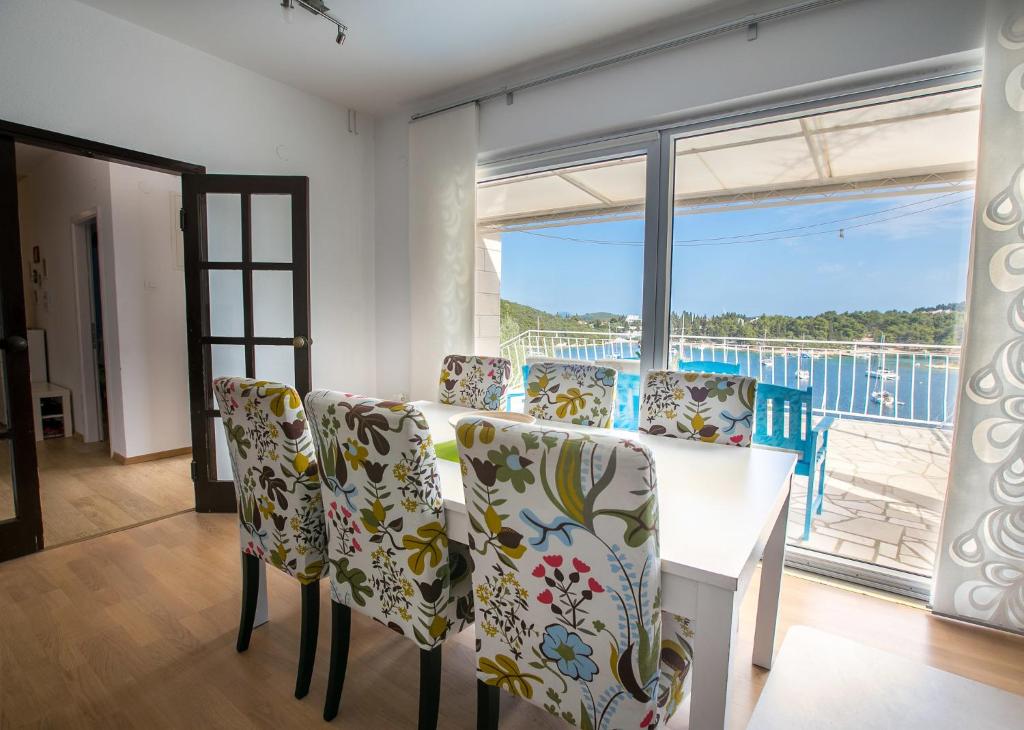 een eetkamer met een tafel en stoelen en een groot raam bij Truly Mediterranean Apartment "Spark" in Korčula