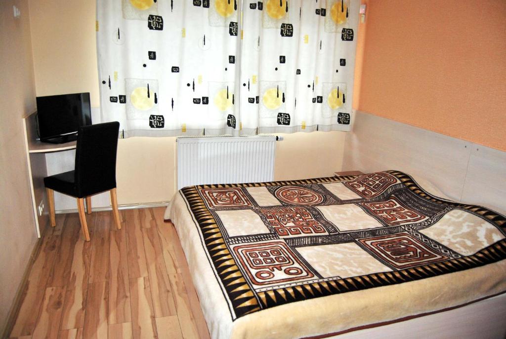een slaapkamer met een bed, een stoel en een raam bij Kambarių nuoma - Šiauliai SAURIDA in Šiauliai