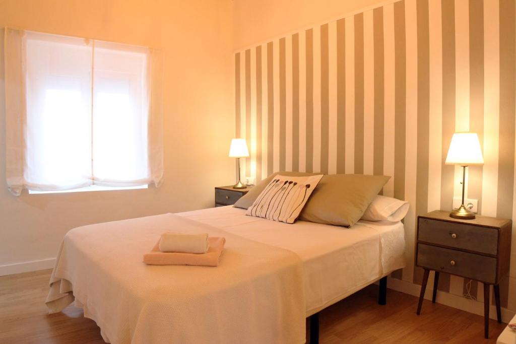 1 dormitorio con 1 cama con 2 lámparas y una ventana en APLUS Apartamentos, Old Town Benidorm, en Benidorm