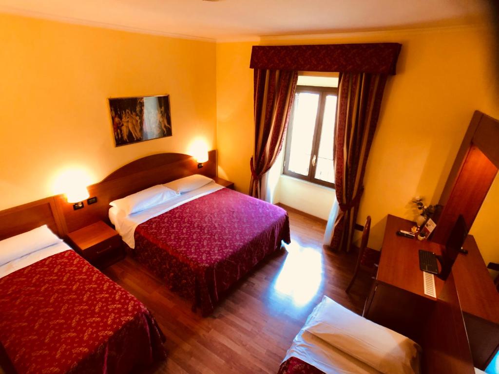 a hotel room with two beds and a window at Saint Peter Inn in Rome