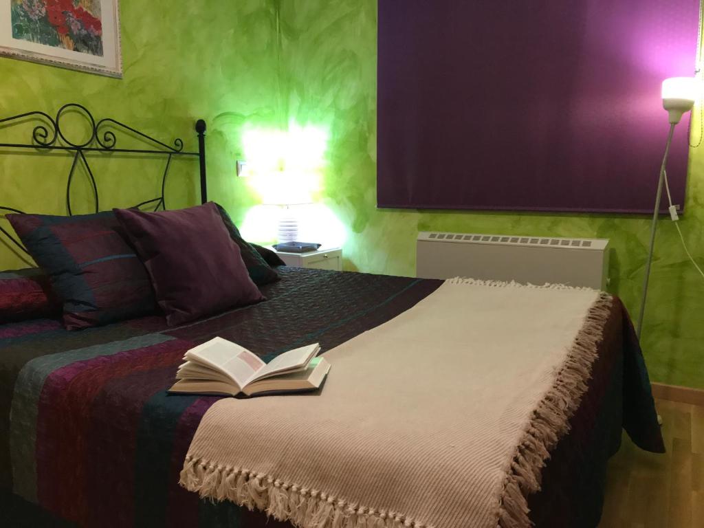 a bedroom with a bed with a book on it at Apartamento La Plazuela in Almagro