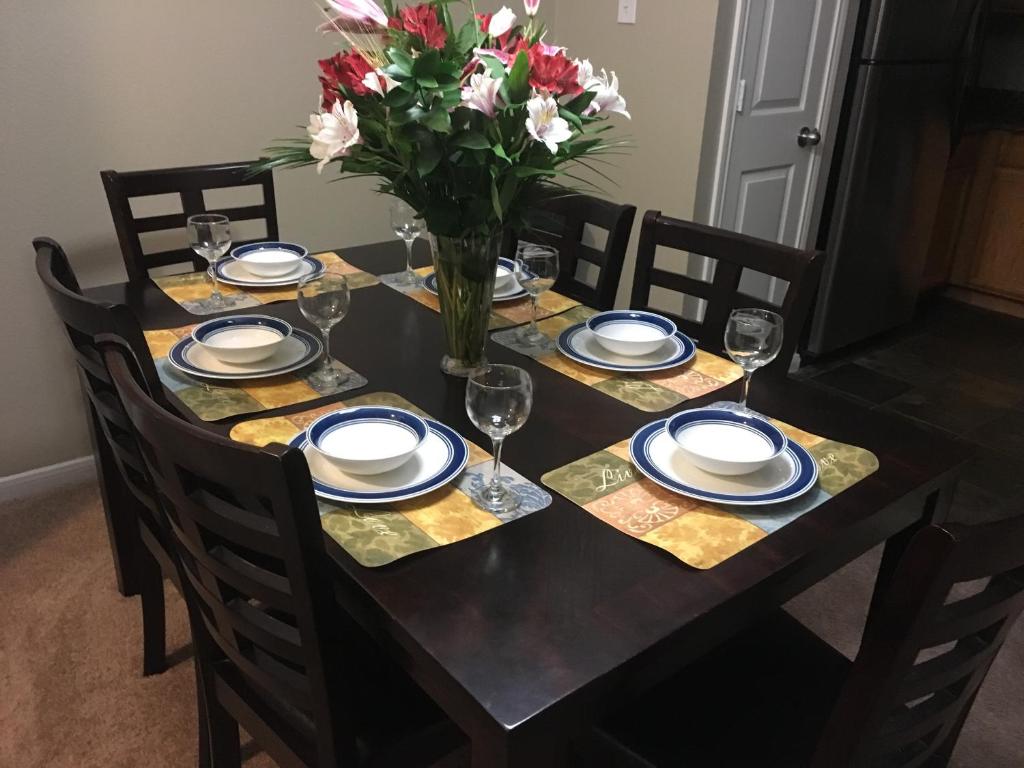 a dining room table with a vase of flowers at Resort Style Apt/Home in Houston Medical Centre in Houston