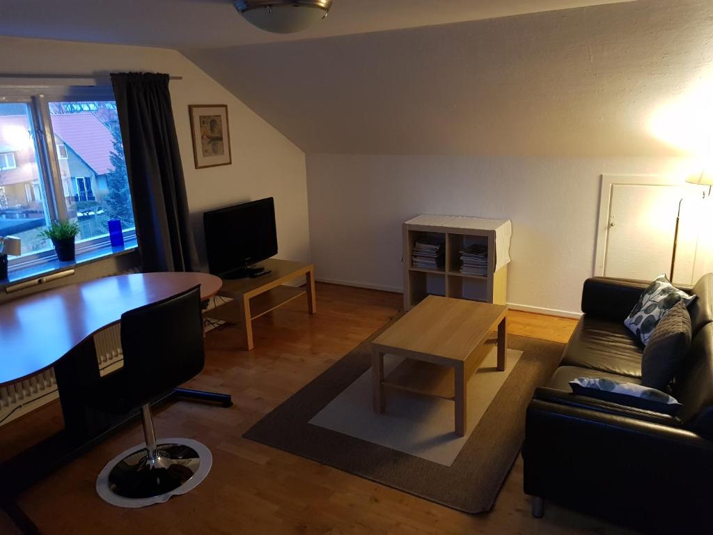 - un salon avec un canapé et une table dans l'établissement Villa Carlotta Apartments, à Lund