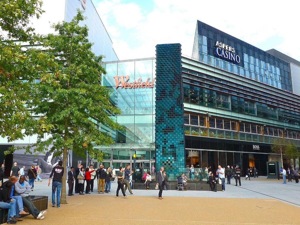 un grupo de personas parados fuera de un edificio en Cozy apartment in Stratford from 18 minutes to Central London en Londres