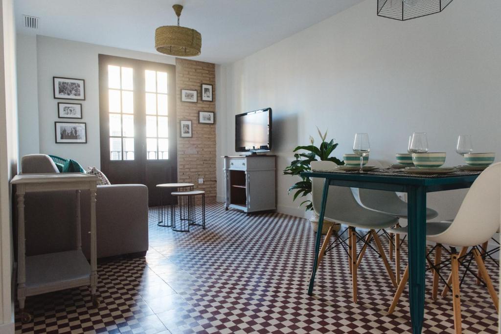 uma sala de estar com uma mesa e uma televisão em El Mirador de Catalina em Sevilha