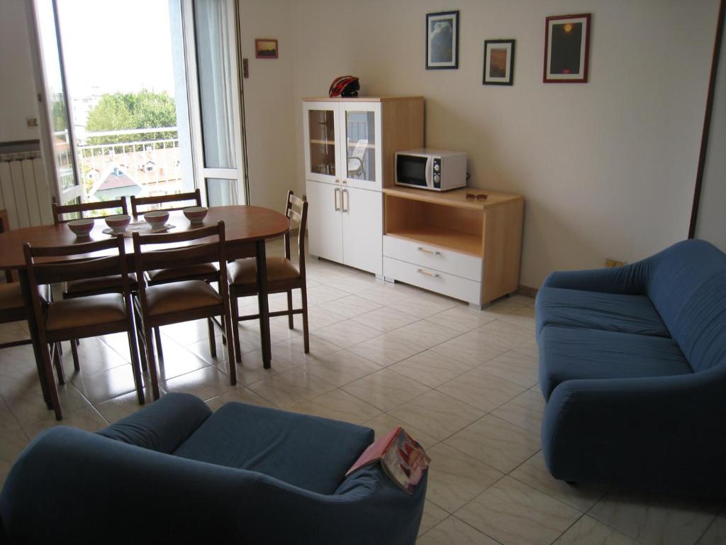 チェゼナーティコにあるAppartamento Adriaticoのリビングルーム(青いソファ、テーブル付)