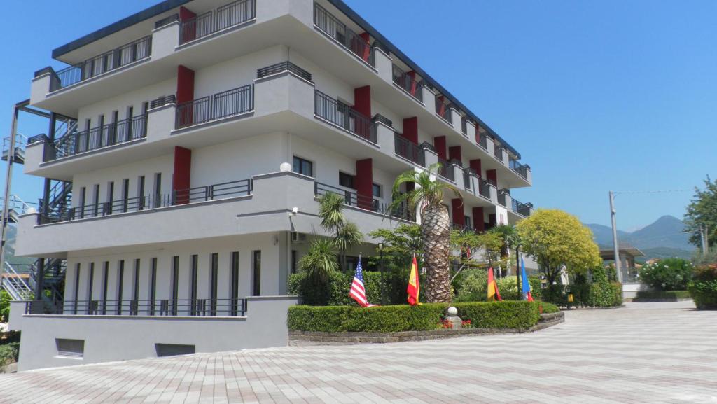 a white building with flags in front of it at Hotel Sant'Elia in SantʼElia Fiumerapido