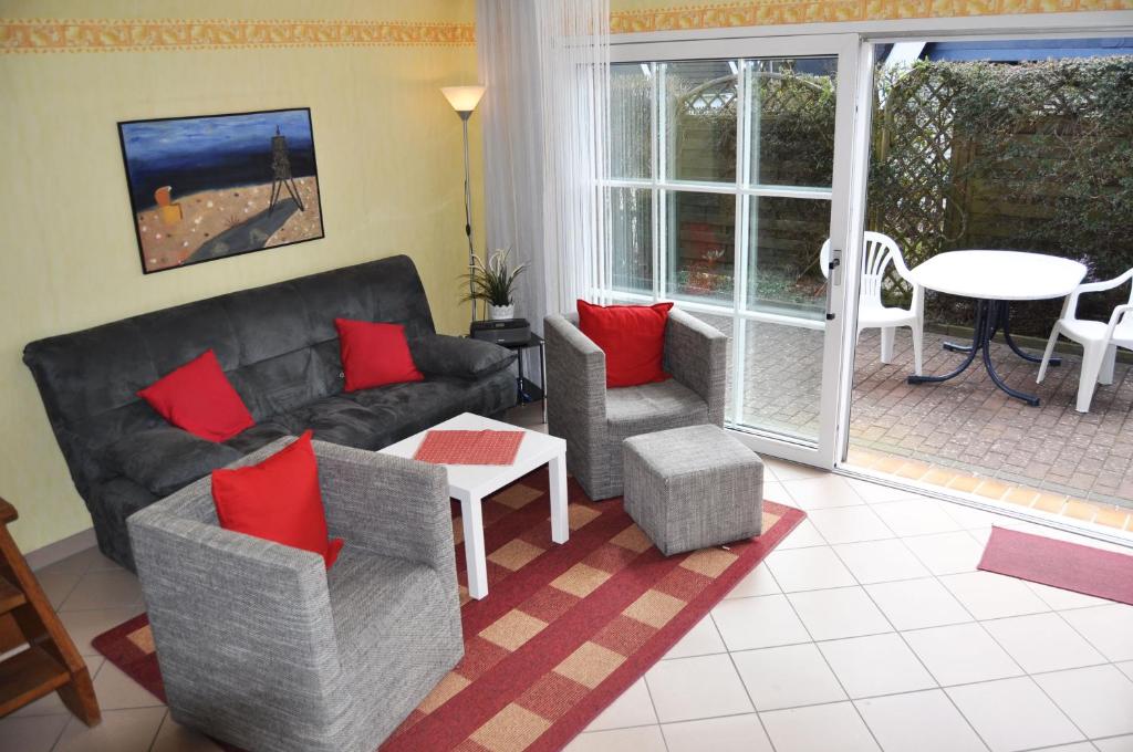 - un salon avec un canapé, des chaises et une table dans l'établissement Ferienhaus Exner hinter dem Deich, à Cuxhaven