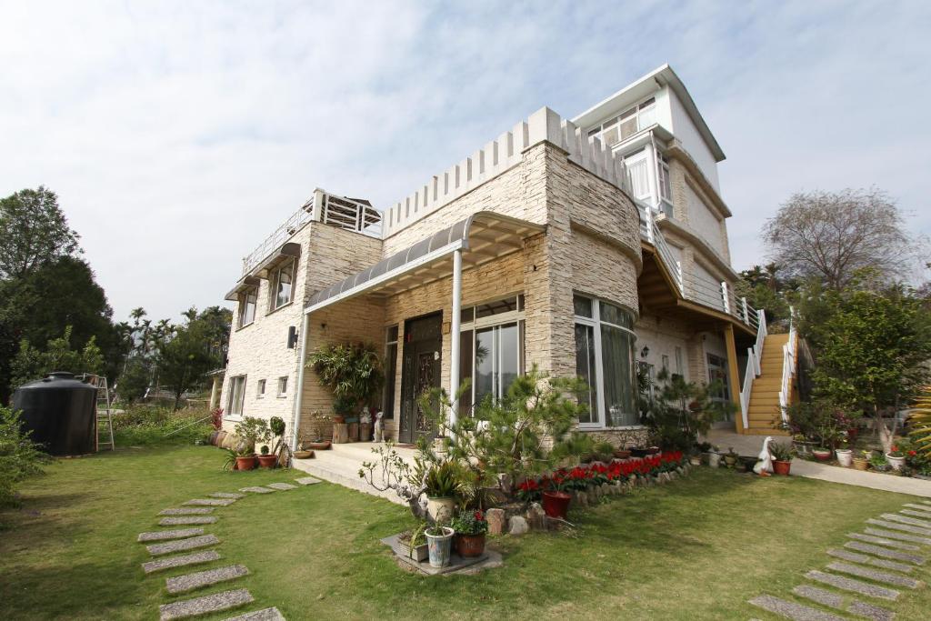 a house with a lawn in front of it at Jingxin Yuan Xiang Ju Homestay in Yuchi