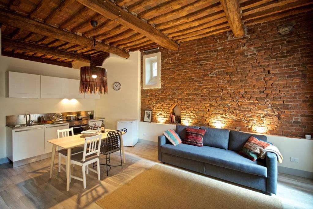 un soggiorno con divano blu e tavolo di Casa Nora a Lucca