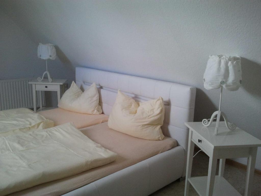 ヴィーク・アウフ・リューゲンにあるAppartmenthaus Am Boddenのベッドルーム1室(枕付きベッド2台、ナイトスタンド付)