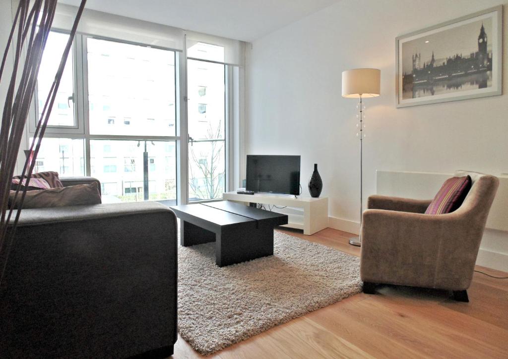 ein Wohnzimmer mit einem Sofa und einem Tisch in der Unterkunft Tower Hill Serviced Apartments in London