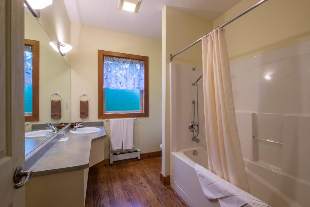 een badkamer met een bad, een wastafel en een douche bij Kiwi Cove Lodge in Ladysmith